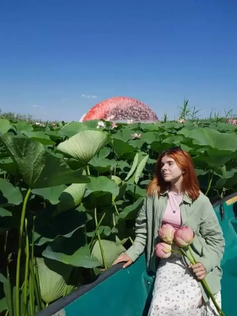 AI Video from prompt: Женщина в лодке держит цветы лотоса среди густог