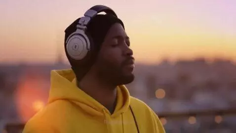 AI Video from prompt: Medium close-up of the DJ nodding to the beat wi