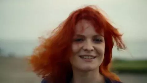 AI Video from prompt: A very beautiful red-haired woman runs towards u