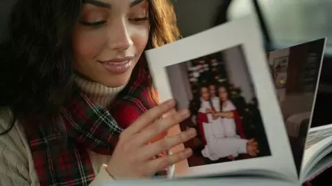 AI Video from prompt: Laura Love is slowly flipping a photo book and r