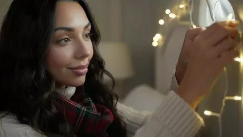 AI Video from prompt: Laura Love is hanging up Christmas lights and th
