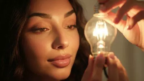 AI Video from prompt: Laura Love is being filmed inspecting a lightbul