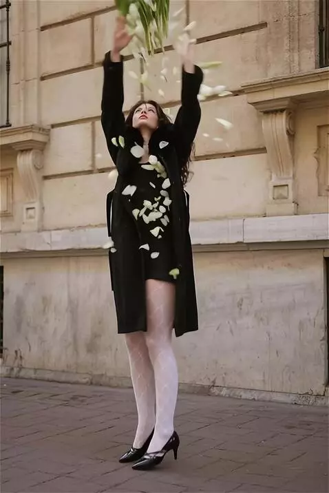 AI Video from prompt: The woman playfully smells the flowers before th