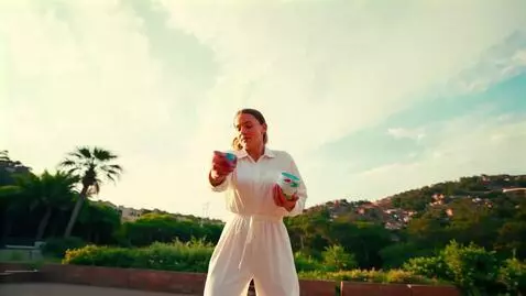 AI Video from prompt: An artist in a painted jumpsuit throws a mixture