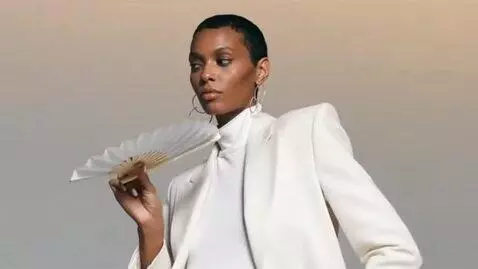 AI Video from prompt: `Fashion video. Model opens white fan quickly th