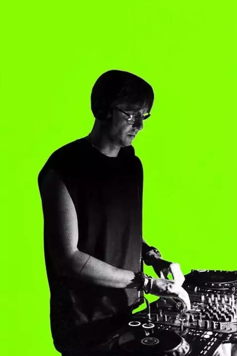 AI Video from prompt: The DJ mixes the music vigorously. He shakes his