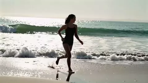 AI Video from prompt: a beautiful  in a short swimsuit runs along the 