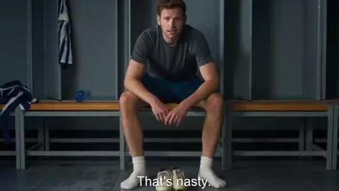 AI Video from prompt: A muscular soccer player siting in the locker ro