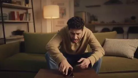 AI Video from prompt: A man sitting on a on a couch in the house phone