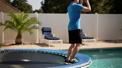 AI Video from prompt: jumps on trampoline falls in pool