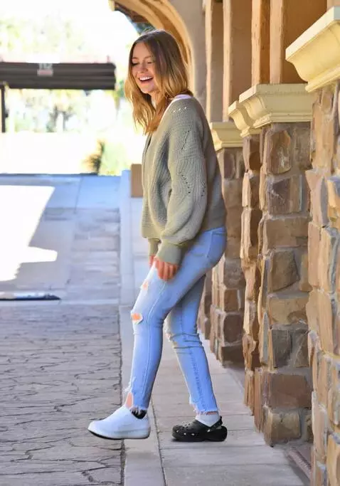 AI Video from prompt: A woman walks sideways, limping slightly on her 