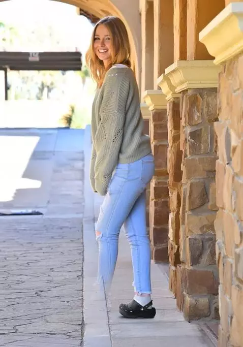 AI Video from prompt: A woman walks sideways, limping slightly on her 