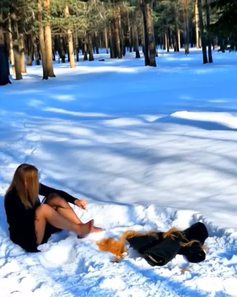 AI Video from prompt: Женщина лёжа на снегу снимает с себя одежду и со