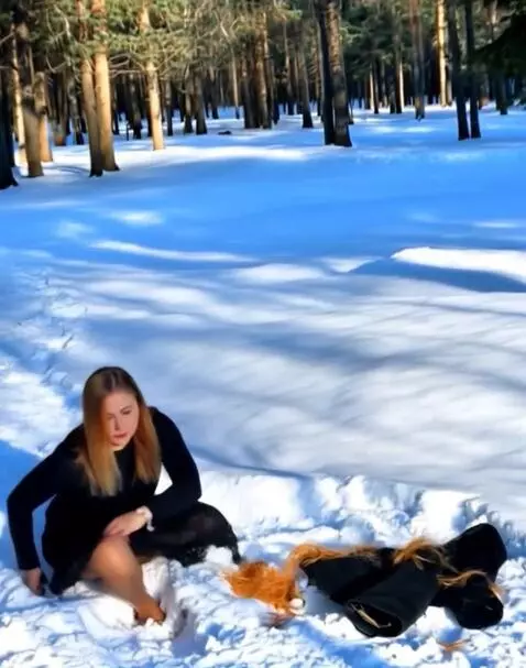 AI Video from prompt: Женщина лёжа на снегу снимает с себя одежду и со