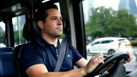 AI Video from prompt: Bus driver driving a bus with a dark blue polo s