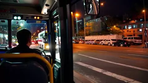 AI Video from prompt: Bus operator on a bus at the red light. Man stan
