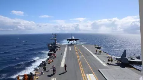 AI Video from prompt: A plane lands on a airplane carrier in the middl