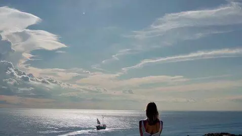 AI Video from prompt: A young woman sits in a calm, motionless pose on