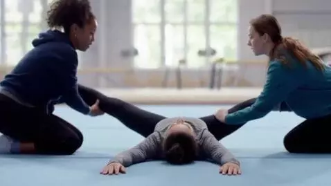 AI Video from prompt: Gymnast A lies on her back on the ground, facing