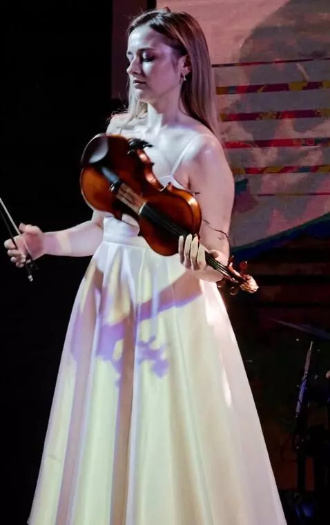AI Video from prompt: Young woman suddenly throws the violin back, the