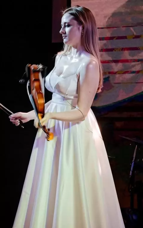 AI Video from prompt: Young woman suddenly throws the violin back, the