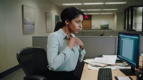 AI Video from prompt: A woman at work then her breasts grow