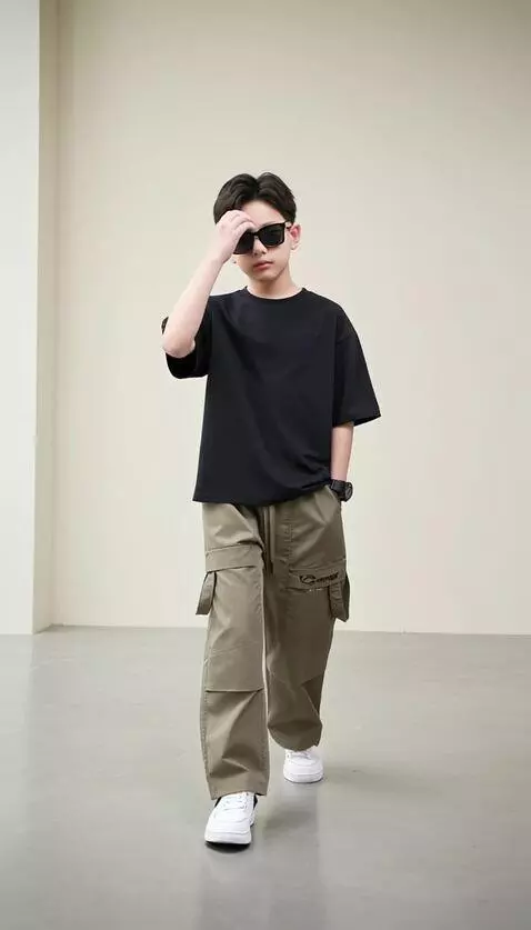 AI Video from prompt: The young boy model walks forward with a confide