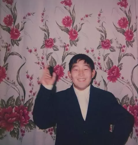 AI Video from prompt: He looks at the camera and waves one hand, smili