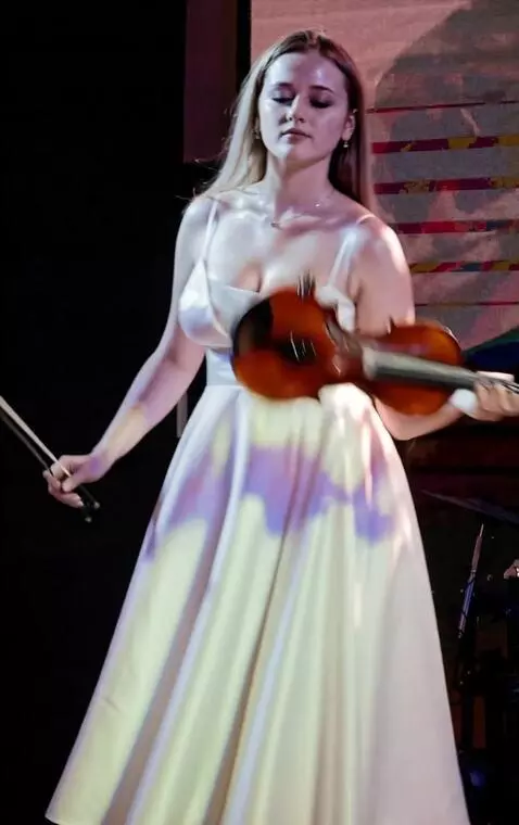 AI Video from prompt: Young woman suddenly throws the violin back, the