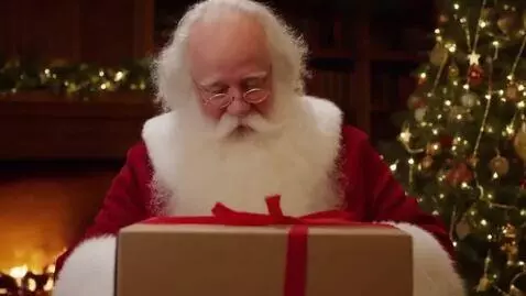 AI Video from prompt: Santa Claus without his hat  opens a box and fin