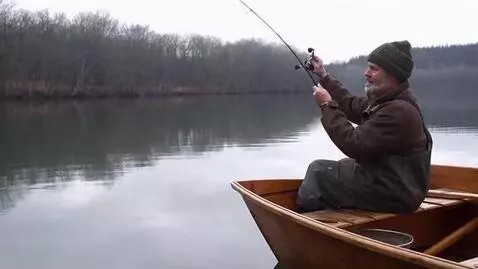 AI Video from prompt: A man sitting in a wooden boat cast a fishing ro