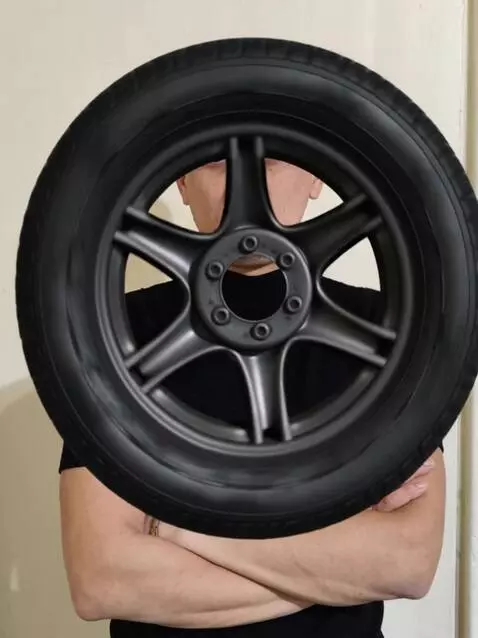 AI Video from prompt: a huge tire spins from inside and a man appears 