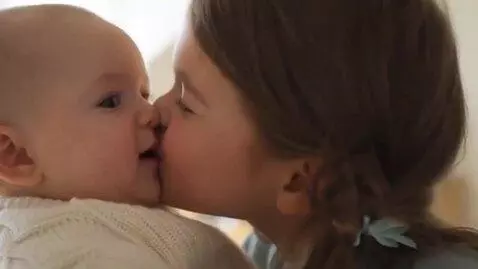 AI Video from prompt: A girl give kiss to a baby