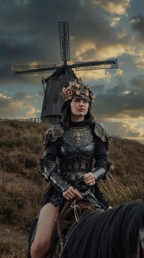 AI Video from prompt: The wind turns the blades of the mill, the woman