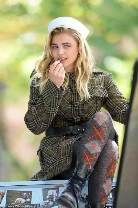 AI Video from prompt: The girl puts lipstick on her lips and looks at 