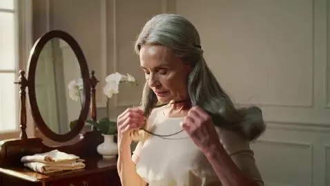 AI Video from prompt: A beautiful old lady removes her hair band and a