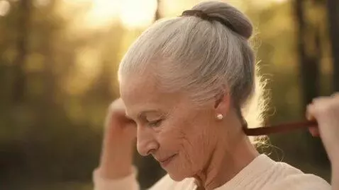 AI Video from prompt: A beautiful old lady removes her hair band and a