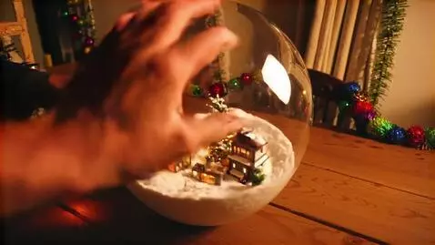 AI Video from prompt: Close-up realistic glass snow globe on rustic wo