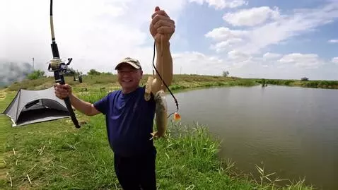 AI Video from prompt: A fisherman in camouflage. He holds a large carp