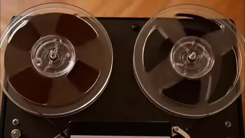 AI Video from prompt: the reels of a reel-to-reel tape recorder are sp