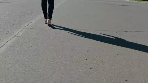 AI Video from prompt: A woman is walking and her shadow stops; some ti