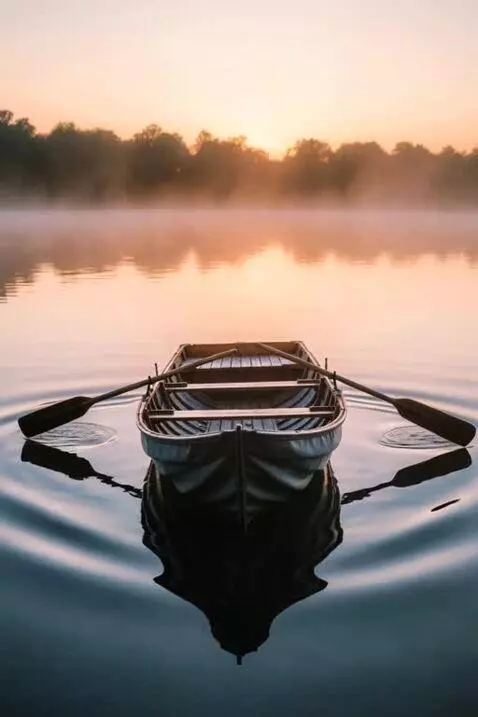 AI Video from prompt: A row boat gently rocks on a fairly calm day, lo