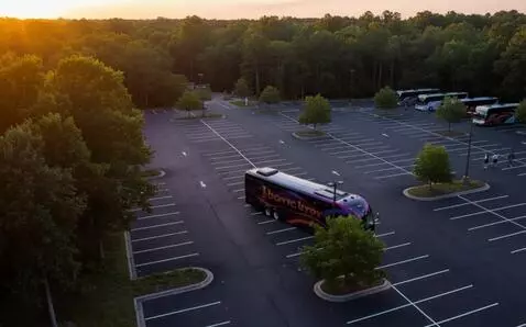 AI Video from prompt: Bus turns around to park near other buses. peopl