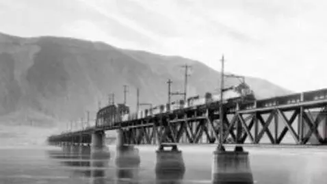 AI Video from prompt: A freight train crossing the bridge over the riv