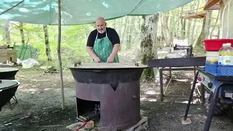 AI Video from prompt: A man is standing in front of a huge cauldron co
