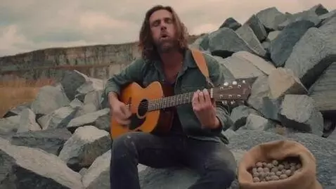 AI Video from prompt: man plays guitar while eating rocks