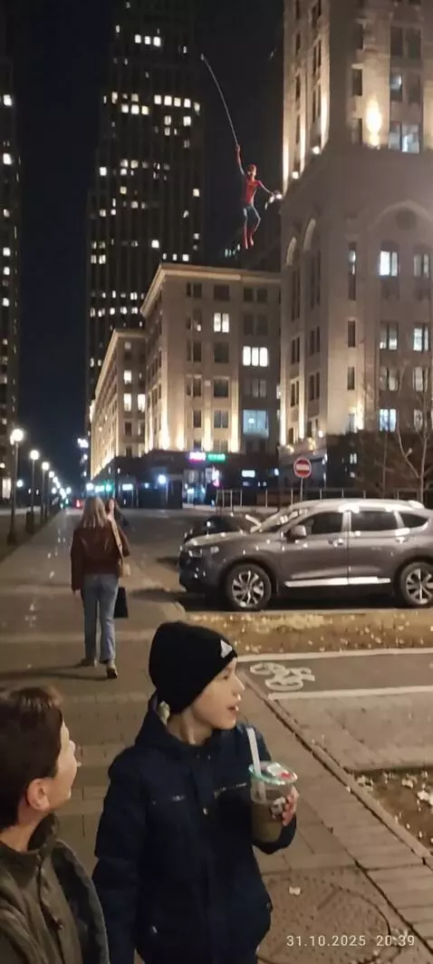 AI Video from prompt: Spider-man descends from a skyscraper on a spide