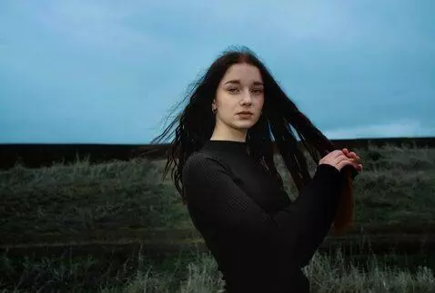 AI Video from prompt: a girl with long hair braids her hair into a bra