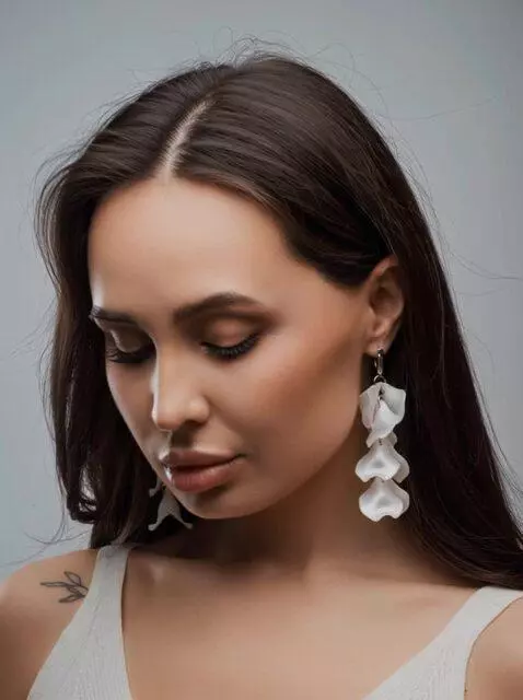 AI Video from prompt: add movement to the earrings, the model tilts he