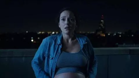 AI Video from prompt: Night. A pregnant woman in a denim shirt stands 